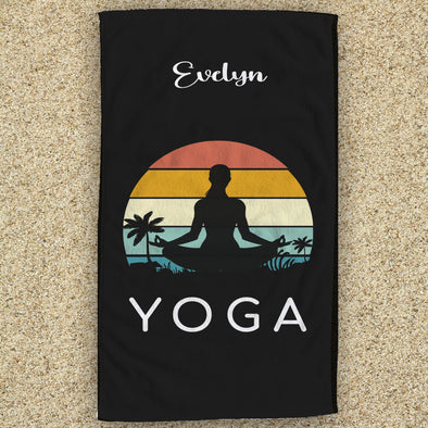 a towel with a woman doing yoga in front of a sunset